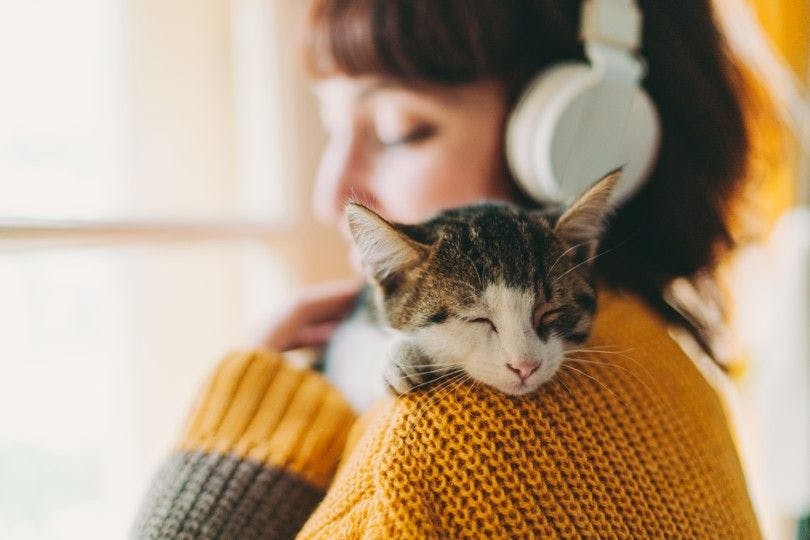 Dame som hører på lydbok med katt